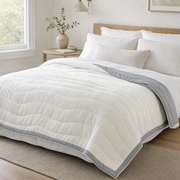 The Drift quilted cooling summer comforter in Cloud White styled on a made bed