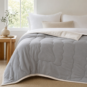 The Drift quilted cooling summer comforter in Stone Gray styled on a made bed