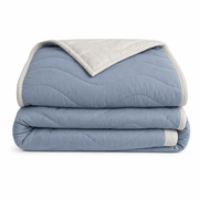The Drift comforter folded, showing the wave quilting and contrasting bound edge