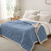 The Drift quilted cooling summer comforter in Harbor Blue styled on a made bed