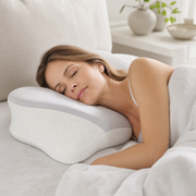 Woman asleep on her side with her head on the raised wing of the pillow
